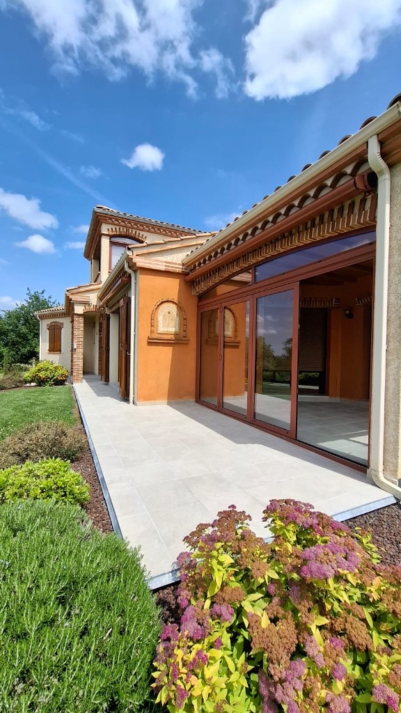 Terrasse extérieure carrelée devant une maison