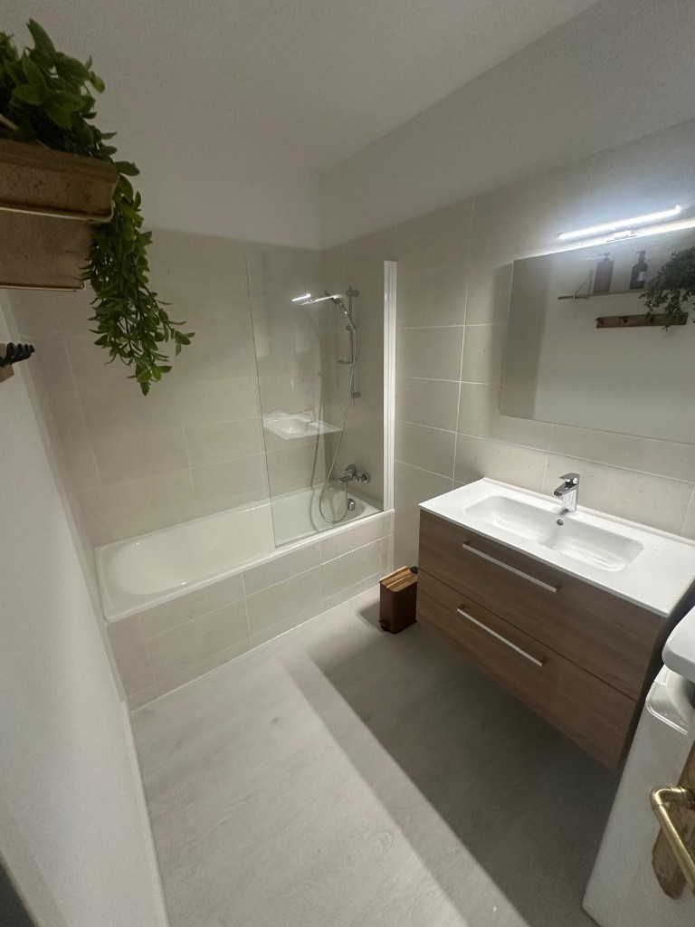 Salle de bain avec baignoire encastrée et meuble vasque en bois