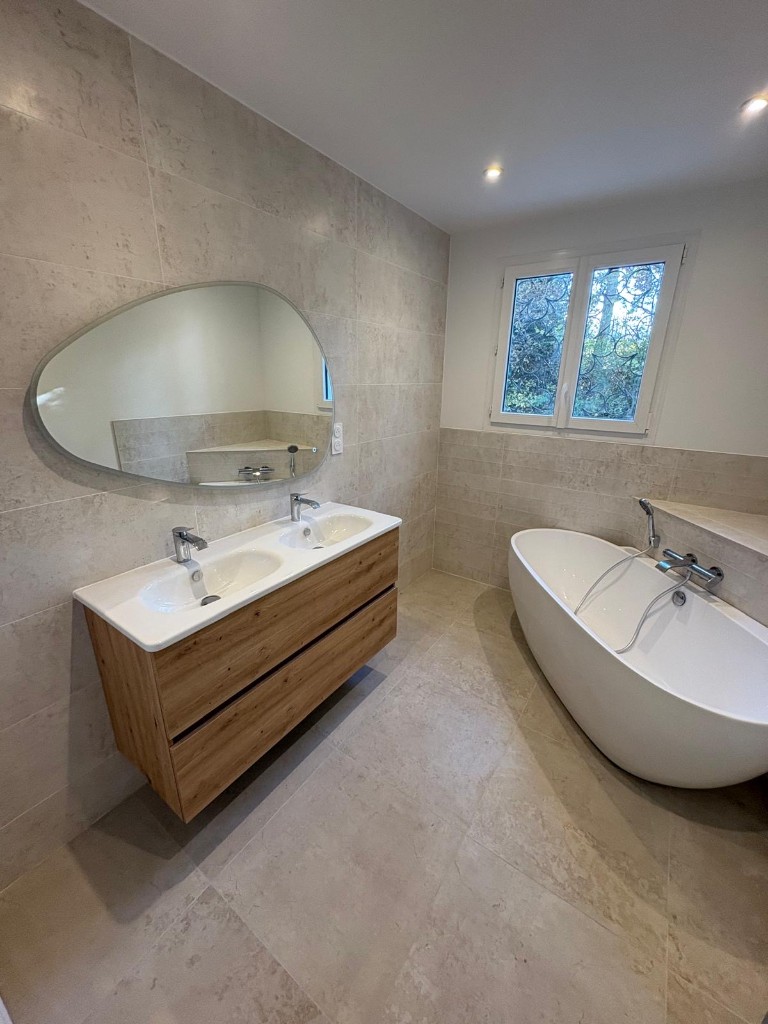 Salle de bain avec baignoire îlot et carrelage pierre