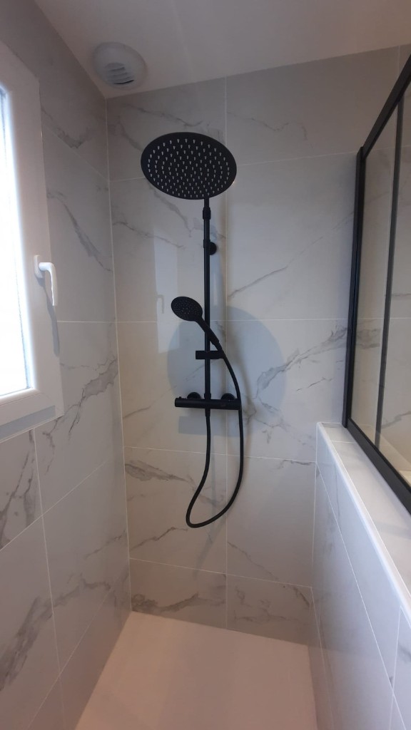 Douche walk-in avec carrelage marbre et robinetterie noire