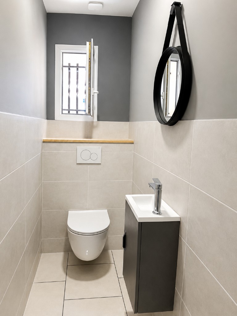 WC suspendu rénové avec carrelage et meuble vasque